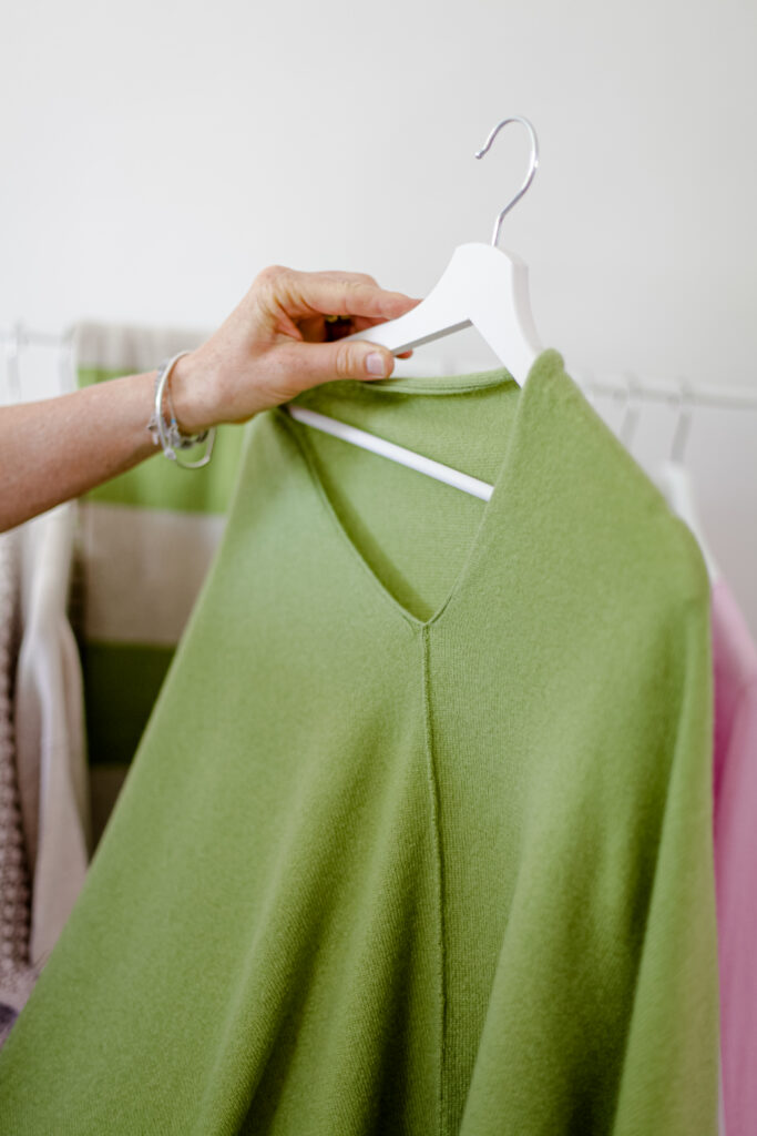 Cashmere-Poncho gruen auf einem Buegel gezeigt