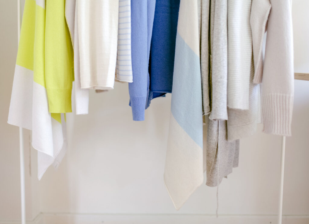 Cashmere-Modelle gestrickt in unterschiedlichen Feinheiten und weiß, blau, hellgraunuancen, auf Kleiderstange angeordnet